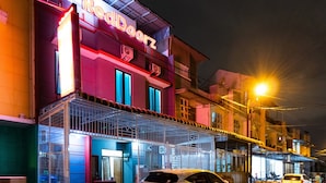 A building with a neon sign reading "RedDoorz" and a covered entrance area. - RedDoorz @ Jalan Dr Mansyur Medan 2 (Medan)
