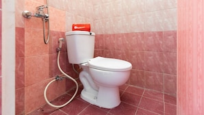A bathroom with a toilet, a shower, and a red toilet paper holder. - RedDoorz @ Jalan Dr Mansyur Medan 2 (Medan)