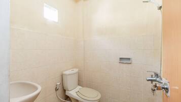 A small, clean bathroom with a toilet, sink, and shower.