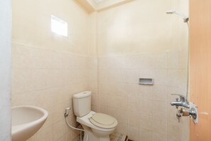 A small, clean bathroom with a toilet, sink, and shower.