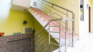 Eine Treppe mit Metallgeländern, einem Schild mit der Aufschrift 'HOME' und einem Schild mit der Aufschrift 'LARASAH' an einer Wand.