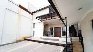 A residential building with a flat roof, a staircase leading to an upper level, and a balcony. - KoolKost Syariah near Alun Alun Kota Bandung (Bandung)