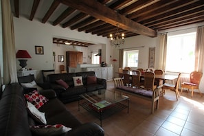 Ein Wohnzimmer mit einer Couch, einem Couchtisch und einem Essbereich mit Stühlen und einem Tisch.