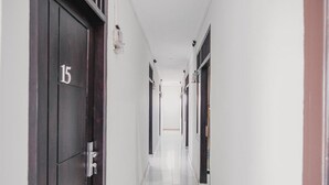 Un pasillo largo y estrecho con puertas a ambos lados, cada una con un número.