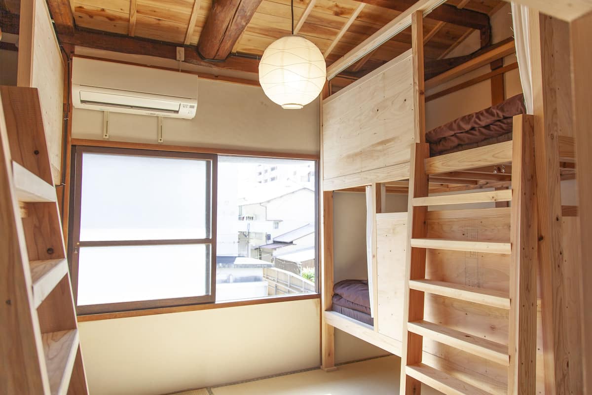 Une pièce dotée d’une grande fenêtre, d’étagères en bois et d’un ventilateur de plafond.