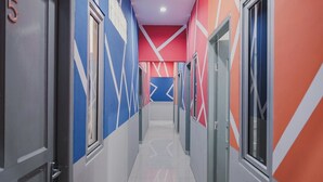 A hallway with doors numbered 5 and 6, leading to rooms. - RedDoorz @ Jalan Sukabangun 2 Palembang (Palembang)