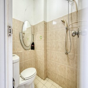 A small bathroom with a toilet, a shower, and a mirror.