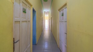 A long, narrow hallway with doors on both sides, each marked with a number. - RedDoorz @ Jalan Cilik Riwut Kapuas (Kualakapuas)