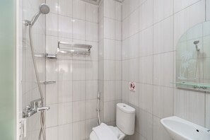 A modern bathroom with a shower, toilet, and sink.