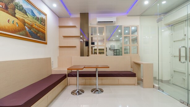 A modern interior with a bench, a table, and a glass partition. - RedDoorz Plus near RS RK Charitas 2 Palembang (Palembang)