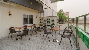 A rooftop patio with outdoor seating, including tables and chairs, and potted plants. - RedDoorz Plus near RS RK Charitas 2 Palembang (Palembang)