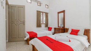 A hotel room with two beds, a wooden wardrobe, a mirror, and a window with curtains. - RedDoorz near Watervang Lubuk Linggau 2 (Lubuklinggau)