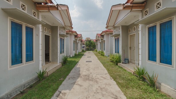 A row of identical buildings with a central pathway. - RedDoorz near Watervang Lubuk Linggau 2 (Lubuklinggau)