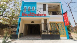 Un immeuble à deux étages, sur lequel on peut voir une enseigne RedDoorz bien visible.