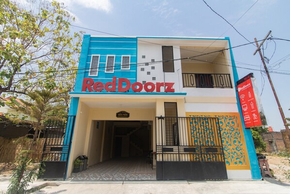 A two-story building with a prominent RedDoorz sign.