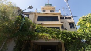 A building with a central tower, multiple windows, and a satellite dish. - RedDoorz @ Frans Seda Kupang (Kupang)