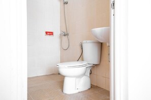 A small, clean bathroom with a toilet, a sink, and a shower.