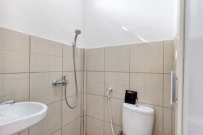 Une salle de bain avec un lavabo, des toilettes et une douche.