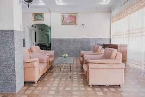 Ein Zimmer mit Marmor- und Holzboden, zwei Sofas, einem Couchtisch und einem gerahmten Bild an der Wand.
