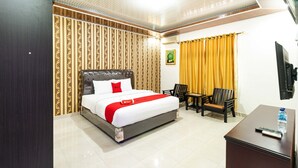 A hotel room with a bed, a desk, and a chair. - RedDoorz Plus near Universitas Methodist Medan (Medan)