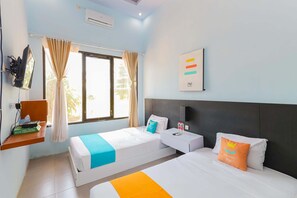A hotel room with two beds, a window with curtains, a mounted TV, a small table with a bottle, and a wall-mounted artwork. - Sans Hotel Borobudur Banyuwangi (Banyuwangi)
