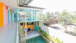 Un bâtiment moderne doté d’un balcon en verre, d’une piscine et d’une enseigne sur laquelle on peut lire « SANS ».