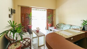 Una habitación con sofá, una mesa y plantas en macetas.