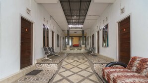 Un pasillo con suelo estampado, un sofá y sillones a lo largo de las paredes.
