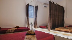 A hotel room with two single beds, a small table, and a window with curtains. - RedDoorz Apartment @ Batam Centre 3 (Batam)