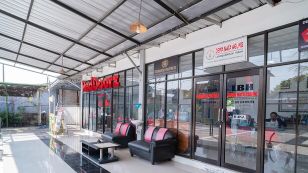 A RedDotz hotel with a glass facade, seating area, and a sign for Dewa Nata Agung. - RedDoorz Syariah @ Winong Nganjuk (Nganjuk)