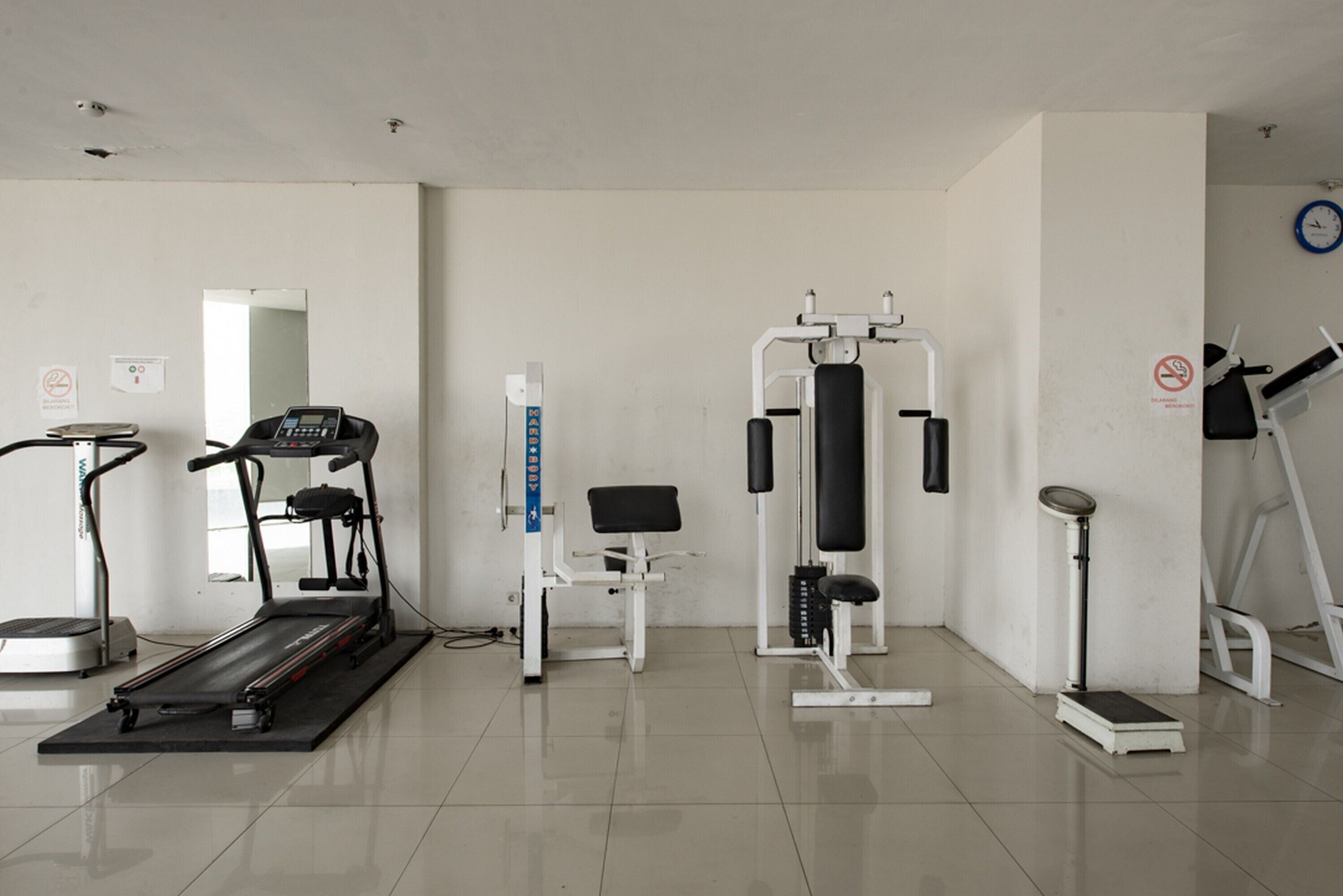 Ein Fitnessstudio mit Laufband, Kraftmaschine und Stepper.