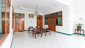 A spacious room with a dining area, wooden cabinets, and a chandelier. - RedDoorz Syariah near Alun Alun Magelang (Magelang)
