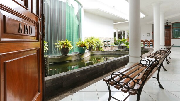 A lobby with a fountain, benches, and a sign reading "AMD". - RedDoorz Syariah near Alun Alun Magelang (Magelang)