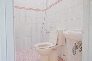 Une salle de bain avec des toilettes, un lavabo et une douche.