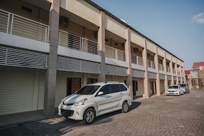 A multi-story building with a parking area.