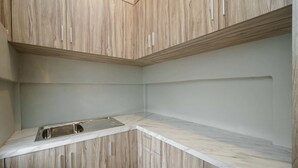 Una cocina con armarios de madera y encimera de mármol.