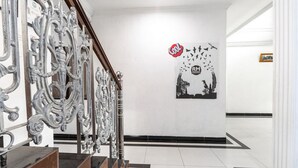Eine Treppe mit aufwendiger Metallgeländerung und einem Schwarz-Weiß-Wandgemälde.