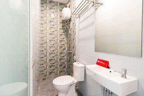 A bathroom with a toilet, a sink, and a shower area with mosaic tiles. - RedDoorz Plus @ Centrium Katamso Medan (Medan)