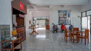 Zona de recepción con mostrador, sillas y una pared que exhibe patinetes.