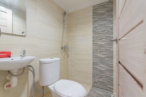 Een badkamer met toilet, wastafel en douche.