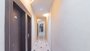 A hallway with doors numbered 205, 206, and 207, leading to rooms. - RedDoorz near Stadion Sanaman Mantikei (Palangkaraya)