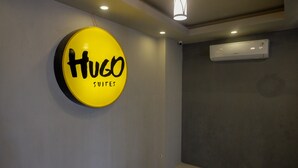 Hotellin kyltti, jossa lukee ”Hugo Suites” ja taustaväri on keltainen.