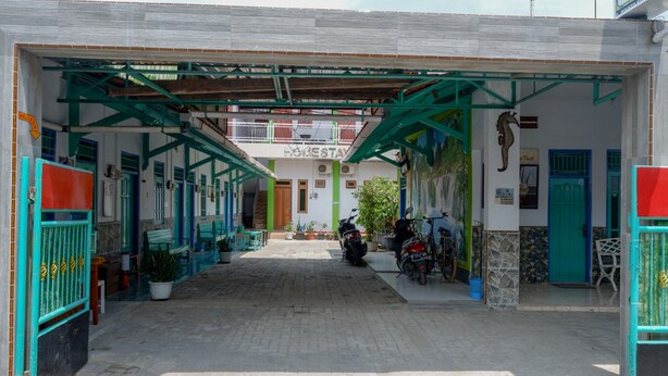 A building with a covered entrance, a sign reading "HOTEL", and a motorcycle parked outside. - RedDoorz Syariah near Alun Alun Balai Kota Tegal (Tegal)