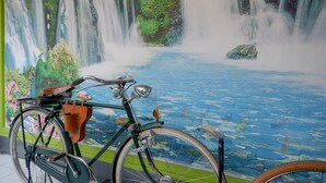 A bicycle in front of a mural depicting a waterfall and a river. - RedDoorz Syariah near Alun Alun Balai Kota Tegal (Tegal)