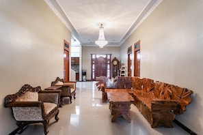 A hallway with a wooden bench, chairs, and a dining table. - RedDoorz Syariah near Exit Toll Banyumanik (Semarang)