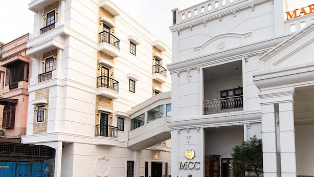 A multi-story building with balconies and a prominent 'MCC' sign.
