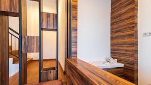 A modern reception area with a wooden reception desk, a phone, and a staircase with wooden railings.