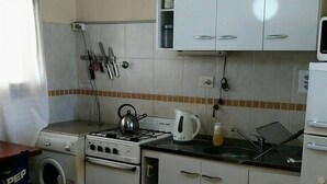 A compact kitchen with a gas stove, a kettle, a washing machine, and a sink. - Hermoso Duplex 2 amb. 1 costa  cochera lavarropas,impecable (Mar del Plata)