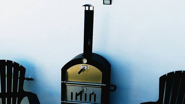 A wood-burning stove with a thermometer, two Adirondack chairs, and a table. - Hermoso Duplex 2 amb. 1 costa  cochera lavarropas,impecable (Mar del Plata)