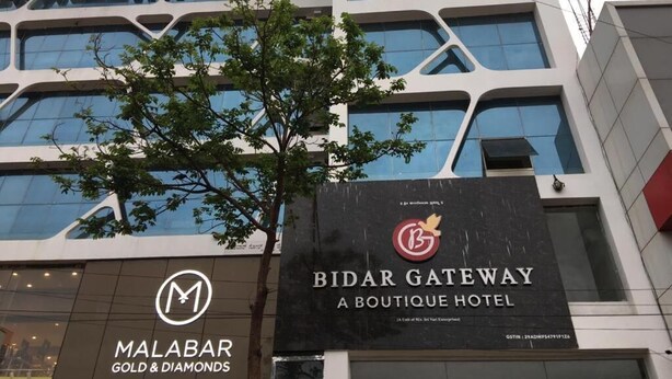 Un edificio con un cartel que indica 'Bidar Gateway Boutique Hotel' y 'Malabar Gold & Diamonds'.